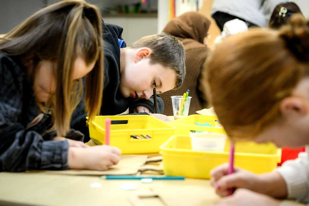 Young people sat at a table drawing